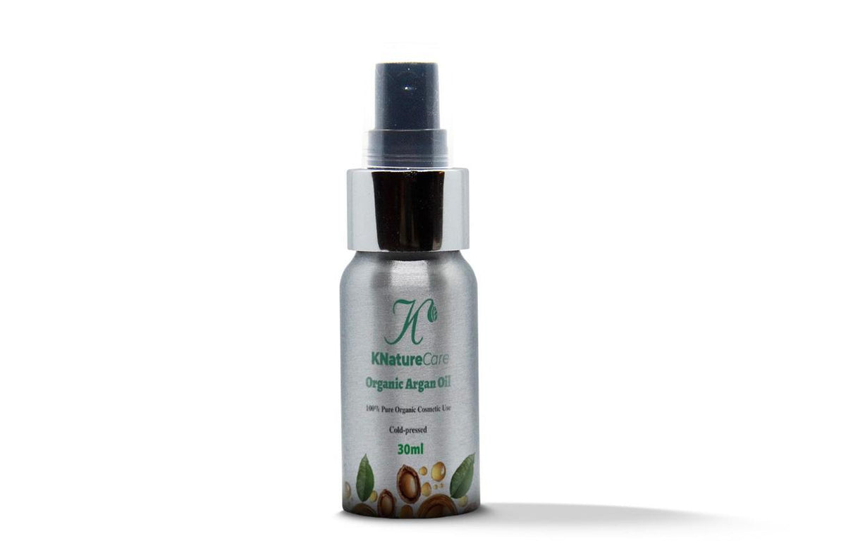 Silver-capped spray bottle of Pure Organic Moroccan Argan Oil on a white background